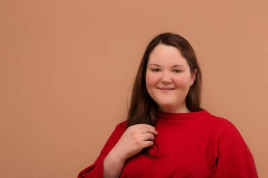 Gülümseyen, mutlu şişman kız. Parlak kıyafetler. Uzun saçlı..