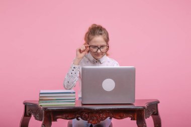 İnternete odaklan. Siyah çerçeveli gözlüklü genç bir kız internette çalışıyor..