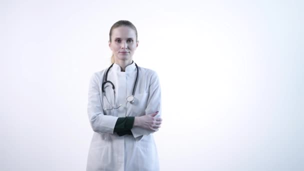 Une belle jeune femme médecin en robe blanche montre un geste du doigt vers le bas . — Video