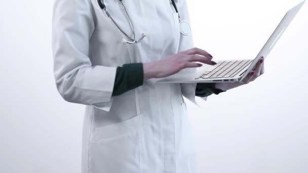 白いローブの医者はノートパソコンで働く。下からのビデオ. — ストック動画