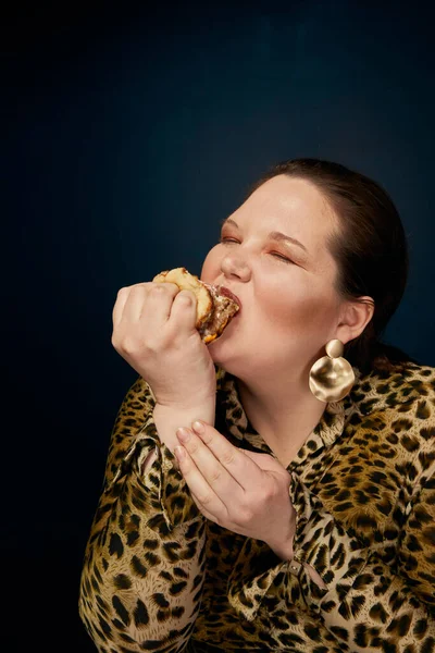 Koncept nenasytnosti. Nadváha. Tlustá žena nejí hamburger chutně. — Stock fotografie