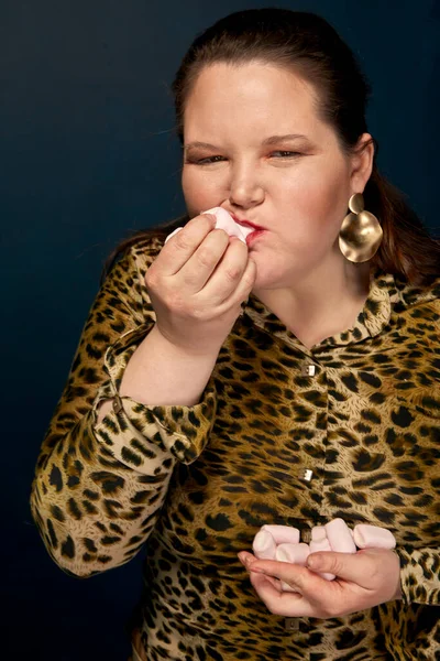 Flicka äter marshmallows. Leopardblus. Överviktig. Porträtt av en fet flicka. — Stockfoto