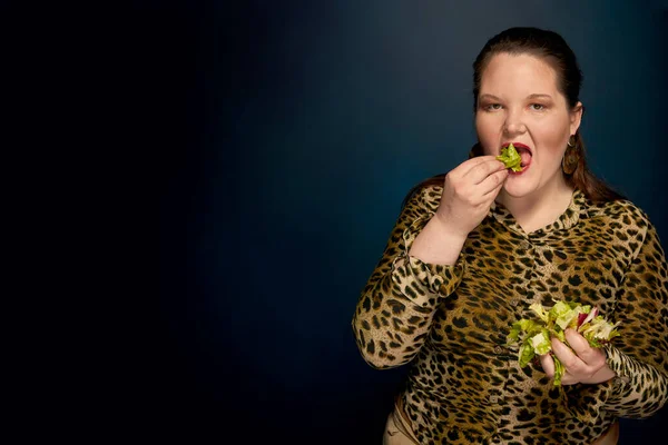 胖女孩吃沙拉，蔬菜。左边是复制空间。照片在演播室. — 图库照片