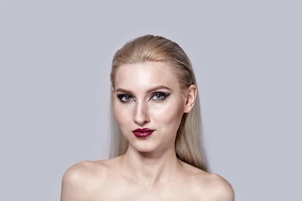 En kvinna med bara axlar med ljus makeup, grå skuggor på ögonen. — Stockfoto