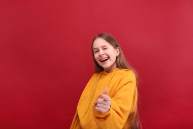 Kırmızı arka planda süveter giyen dansçı kız..