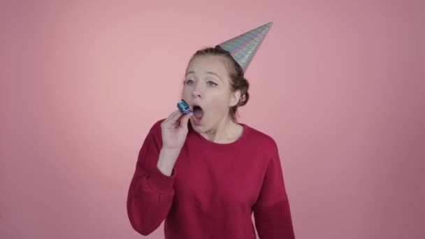 Fêtes d'anniversaire. Une fille dans une casquette et une corne festive . — Video