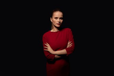 Siyah arka planda kırmızı elbiseli genç bir kadın..