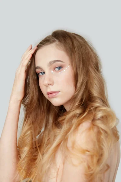 Porträtt av en vacker ung flicka med ljust vågigt hår. — Stockfoto