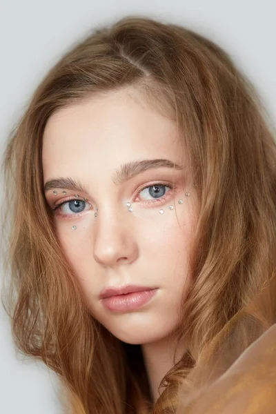 En ung vacker flicka med blå ögon och långt blont hår. — Stockfoto