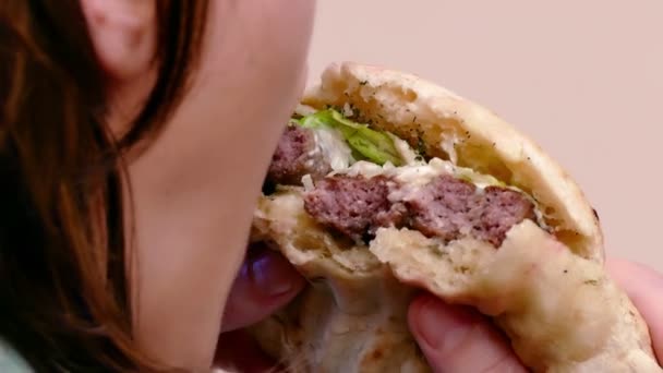 Mujer Joven Está Comiendo Una Jugosa Hamburguesa Con Cerdo Ensalada — Vídeos de Stock