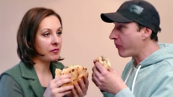 Pareja Joven Comiendo Una Jugosa Hamburguesa Con Carne Cerdo Ensalada — Vídeo de stock