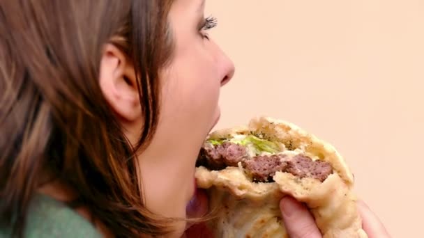 Mujer Joven Está Comiendo Una Jugosa Hamburguesa Con Cerdo Ensalada — Vídeo de stock