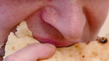 Genç adam domuz eti ve yeşil salata, 4k ile sulu hamburger yiyor Video klip