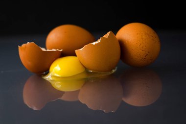 Tabakta tam ve kırılmış çiğ tavuk yumurtası ve yumurta sarısı proteini Paskalya yumurtalarının tarifini takip eder.