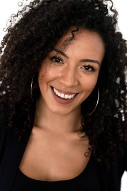 Siyah giyinmiş kıvırcık saçlı Latin bir kadının izole edilmiş portresi.