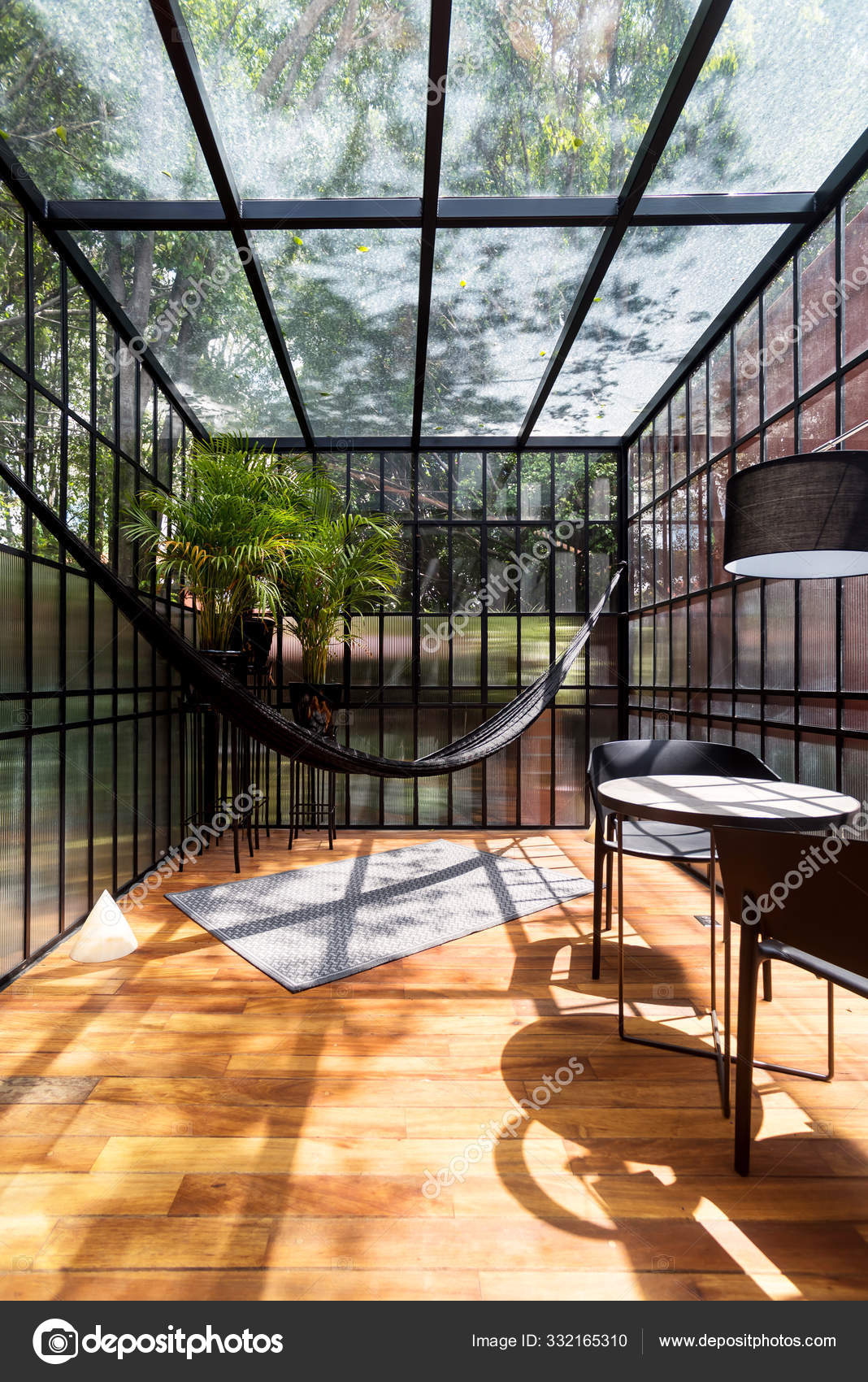 Modern sunroom with a hammock and some plants Stock Photo by