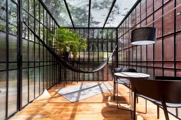 Modern sunroom with a hammock and some plants — Stock Photo, Image