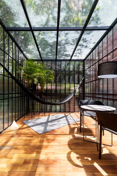 Modern sunroom with a hammock and some plants — Stock Photo, Image