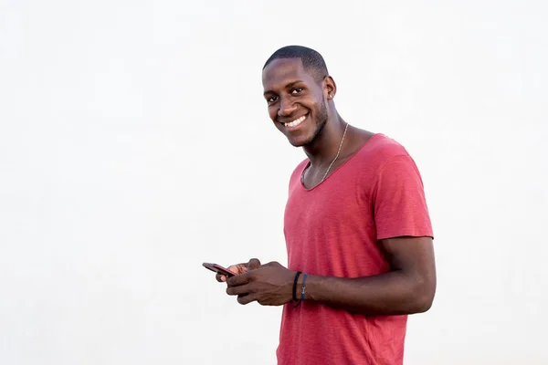 Porträt eines Afrikaners, der auf seinem Handy SMS schreibt — Stockfoto