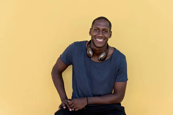 Porträt eines Afrikaners mit Kopfhörern an bunter Wand — Stockfoto