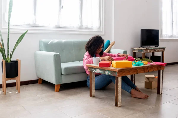 Latynoska kobieta pakowanie ręcznie robione prezenty rzemiosła na stole w domu — Zdjęcie stockowe