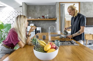 Çift mutfakta kahvaltı yapıyor.