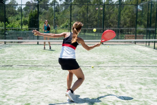 Dışarıda Padel oynayan iki kadın.