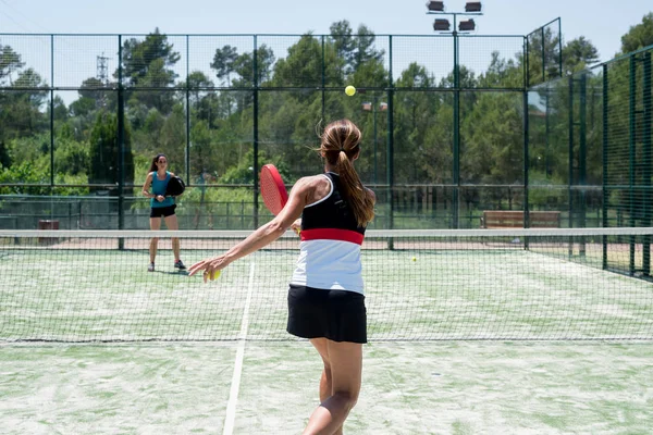 Dışarıda Padel oynayan iki kadın.