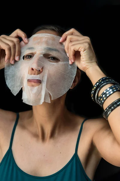 Brunette woman With A Sheet Moisturizing Mask On Her Face — Stock Photo, Image