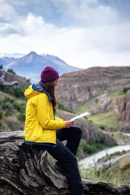 Yürüyüş yapan bir kadın, El Chalten, Patagonya, Arjantin 'deki bir yürüyüş gününde haritaya bakar.
