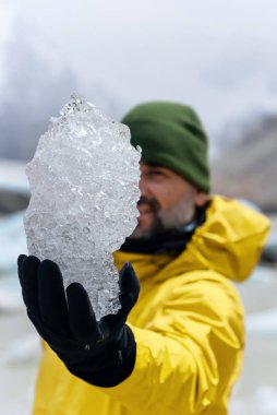 Laguna Torre, Chalten, Arjantin 'de kocaman bir buz parçası tutan bir adam. 