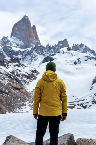 Un excursionista con una chaqueta amarilla sobre la base de Fitz Roy Mountain en Patagonia, Argentina. — Foto de Stock