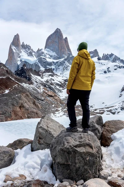 Un excursionista con una chaqueta amarilla sobre la base de Fitz Roy Mountain en Patagonia, Argentina. — Foto de Stock