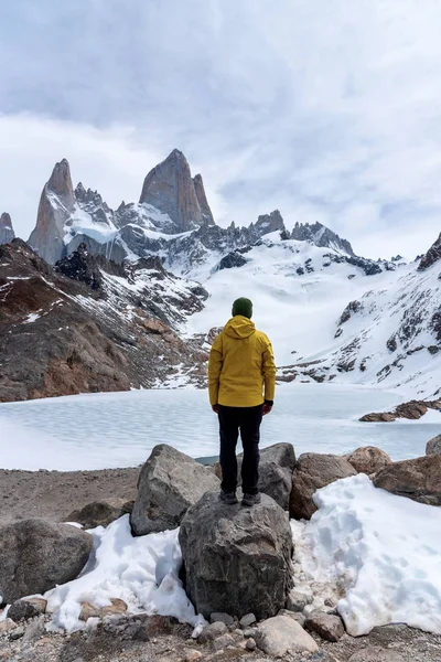 Um caminhante com uma jaqueta amarela na base da Montanha Fitz Roy na Patagônia, Argentina — Fotografia de Stock