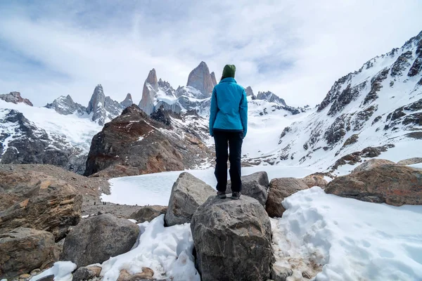 Egy kék kabátos túrázó nő a Fitz Roy hegy lábánál Patagóniában, Argentínában. — Stock Fotó