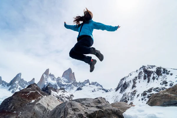 アルゼンチンのパタゴニアにあるフィッツ・ロイ山の麓をジャンプするハイカー女性 — ストック写真