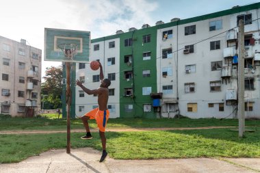 Genç Afrikalı Amerikalı Adam Küba 'da açık havada basketbol oynuyor.