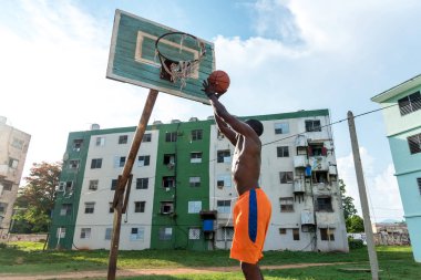 Genç Afrikalı Amerikalı Adam Küba 'da açık havada basketbol oynuyor.