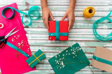 El yapımı el yapımı hediyeleri evdeki masaya saran kadın.