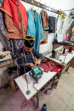 5 Mart 2019, dikiş makinesi kullanan yaşlı bir terzi. Yazd, İran