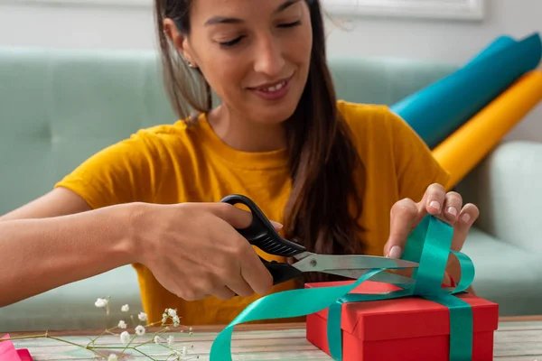 Frau verpackt handgefertigte Geschenke zu Hause auf den Tisch — Stockfoto