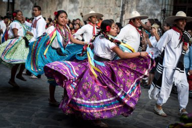 28 Temmuz 2019: Meksika, Oaxaca 'daki Guelaguetza geçit töreninde dans eden renkli geleneksel elbiseli güzel dansçılar