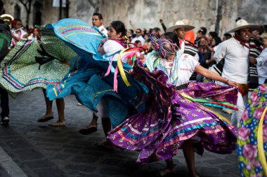 28 Temmuz 2019: Meksika, Oaxaca 'daki Guelaguetza geçit töreninde dans eden renkli geleneksel elbiseli güzel dansçılar
