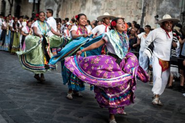 28 Temmuz 2019: Meksika, Oaxaca 'daki Guelaguetza geçit töreninde dans eden renkli geleneksel elbiseli güzel dansçılar