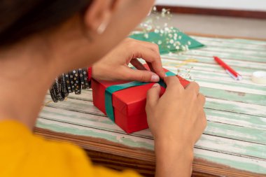 El yapımı el yapımı hediyeleri evdeki masaya saran kadın.
