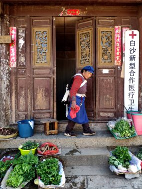 18 Mart 2019: Geleneksel Bai Sha Naxi köyünde sebze satan kadın. Baisha, Yunnan, Çin