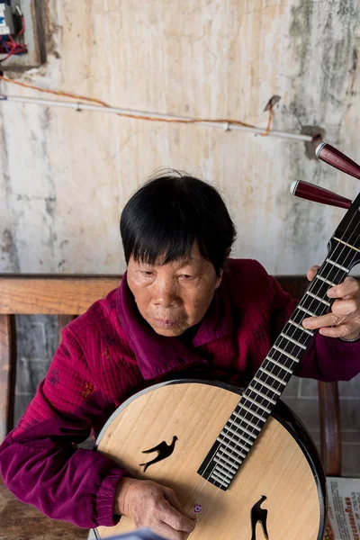 March 7, 2019: Senior chinese woman playing a Traditional Chinese musical instrument in Jianshui, Yunnan, China — Stock Photo, Image