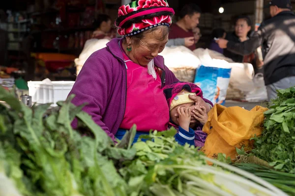 14 maart 2019: Grootmoeder met kleinzoon op de markt, Xizhou, Yunnan, China — Stockfoto