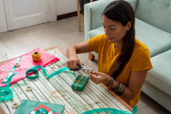 집 식탁 위에서 수제 공예품을 싸고 있는 여성 — 스톡 사진