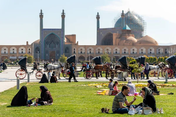 2 maart 2019: Iraanse mensen rusten uit en houden een picknick op het gras op het Naghsh-e Jahan plein. Isfahan, Iran — Stockfoto